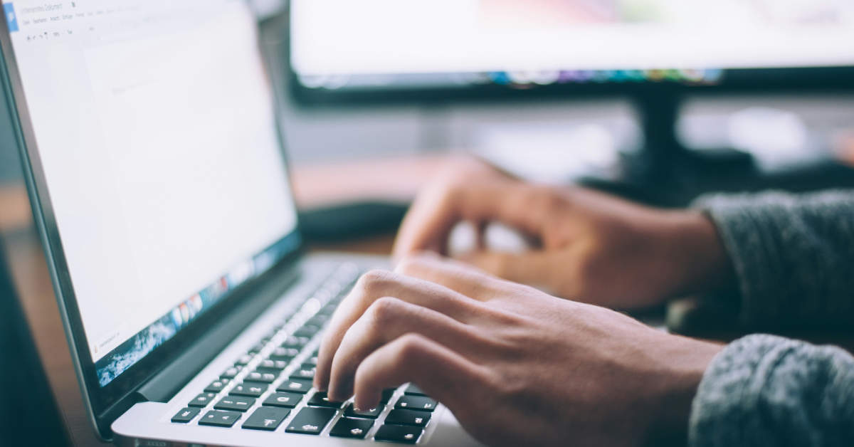 person using laptop showing hands on keyboard